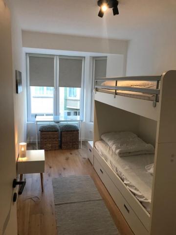 a room with a bunk bed and a window at Quality Time appartement met gesloten garagebox in De Panne