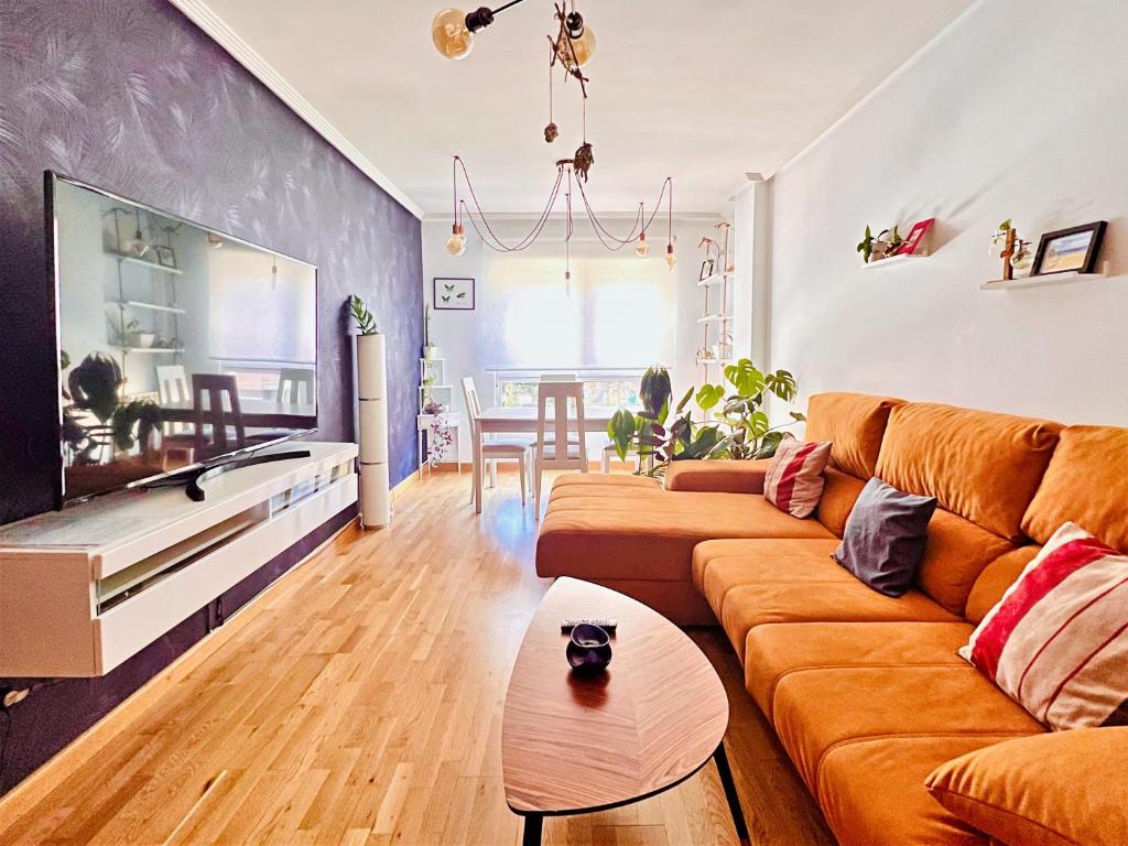 salon z kanapą i telewizorem w obiekcie Housingleon- Casa Oliva con Garaje w mieście León