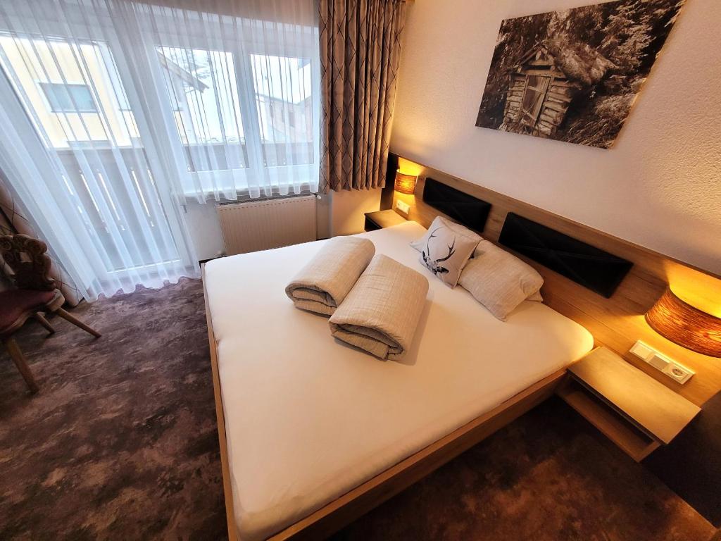 A bed or beds in a room at Apart Garni Jägerheim