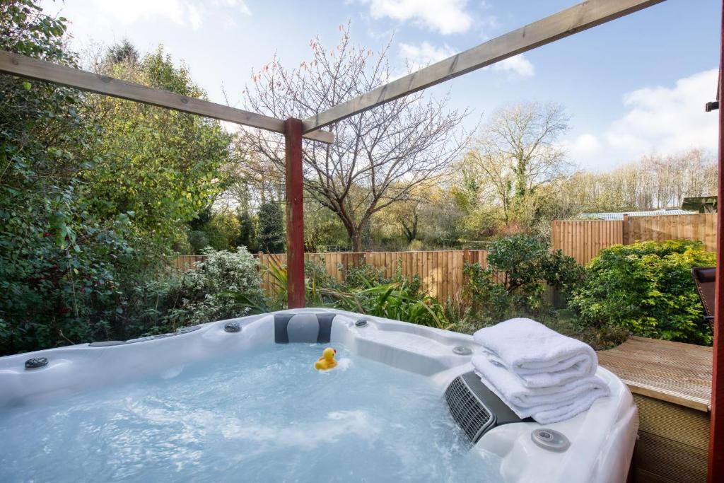 a jacuzzi tub in a backyard at White Cross Cottage in Woodbury