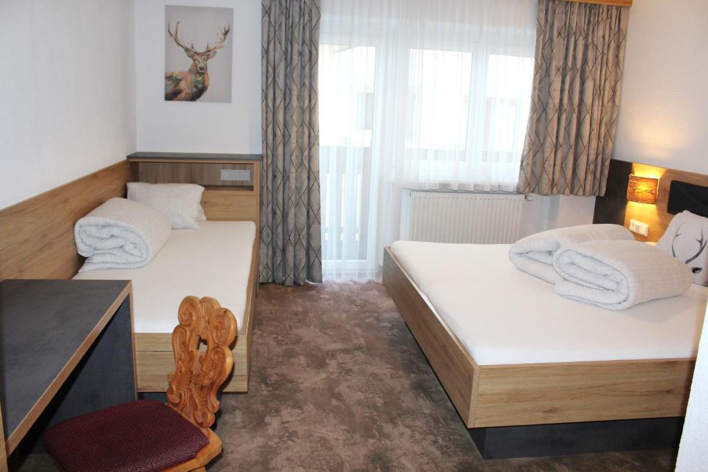 A bed or beds in a room at Apart Garni Jägerheim