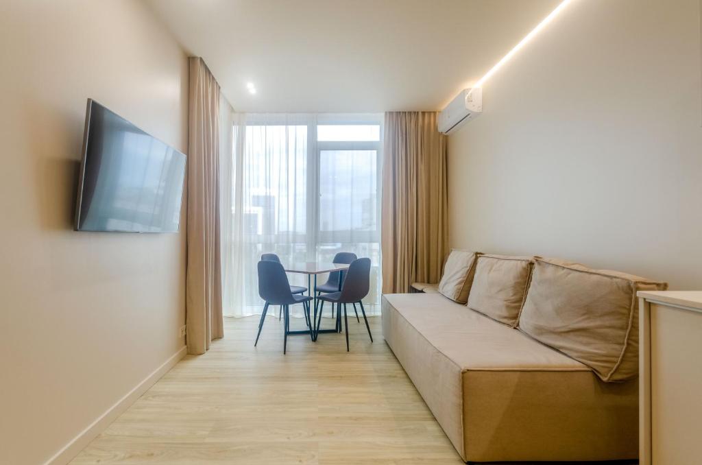 een woonkamer met een bank en een tafel bij 638 Cozy apartment in the residential complex "French Quarter" in Kiev