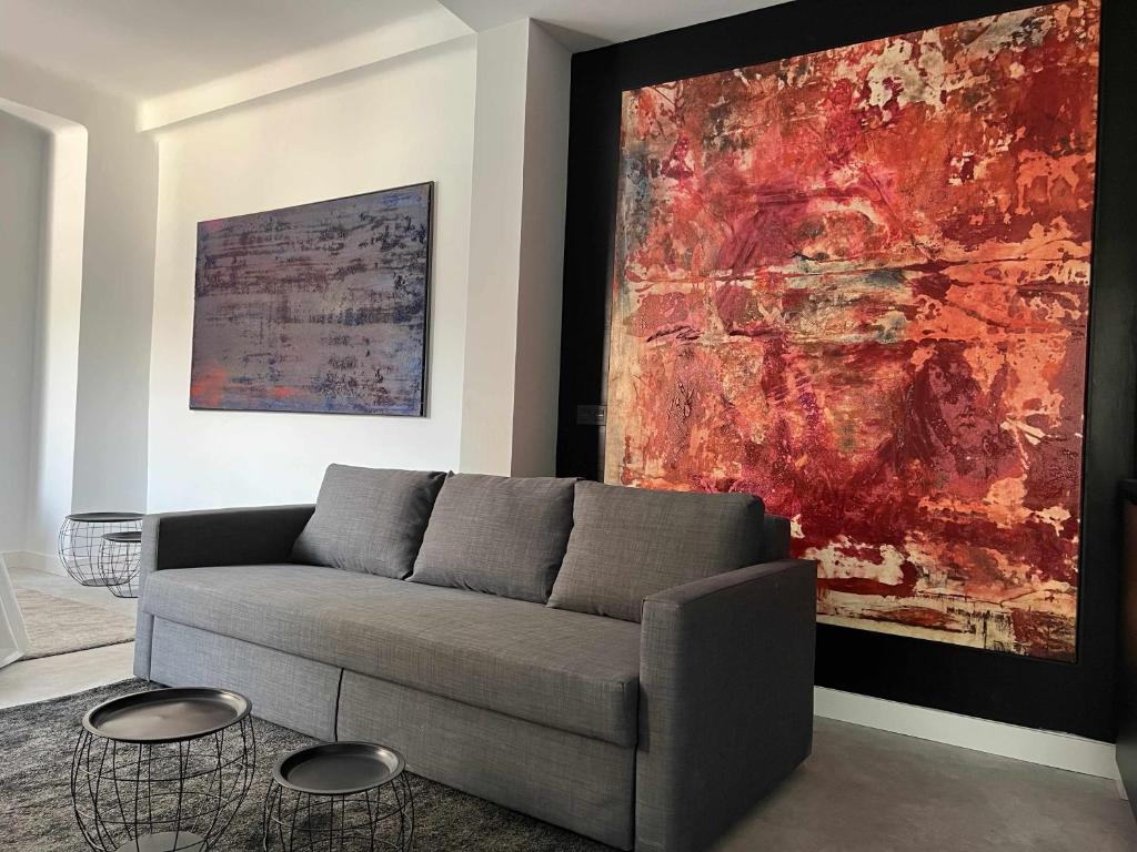 uma sala de estar com um sofá e uma pintura grande em Eneldo modern & luxury em Málaga