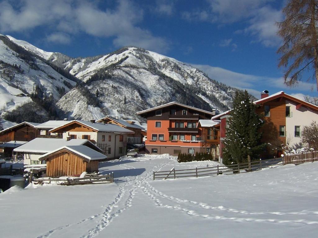 a snow covered town with a mountain in the background at Frühstücks- Pension Sonnblickhof inklusive SommerCard in Rauris