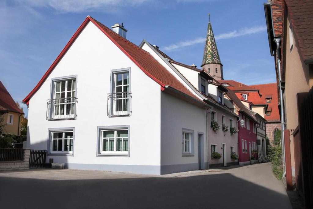 ein weißes Haus mit rotem Dach und einer Kirche in der Unterkunft Ferienhaus Christina in Bad Windsheim