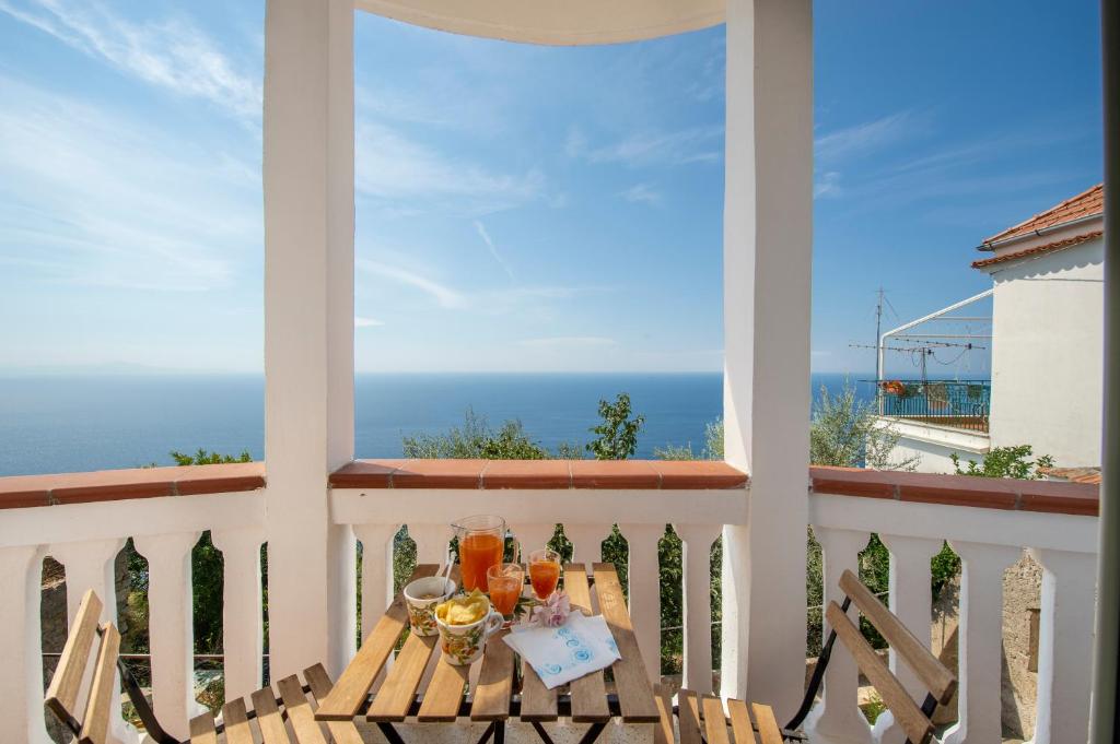 Una mesa en un balcón con vista al mar. en Regina house Furore, en Furore