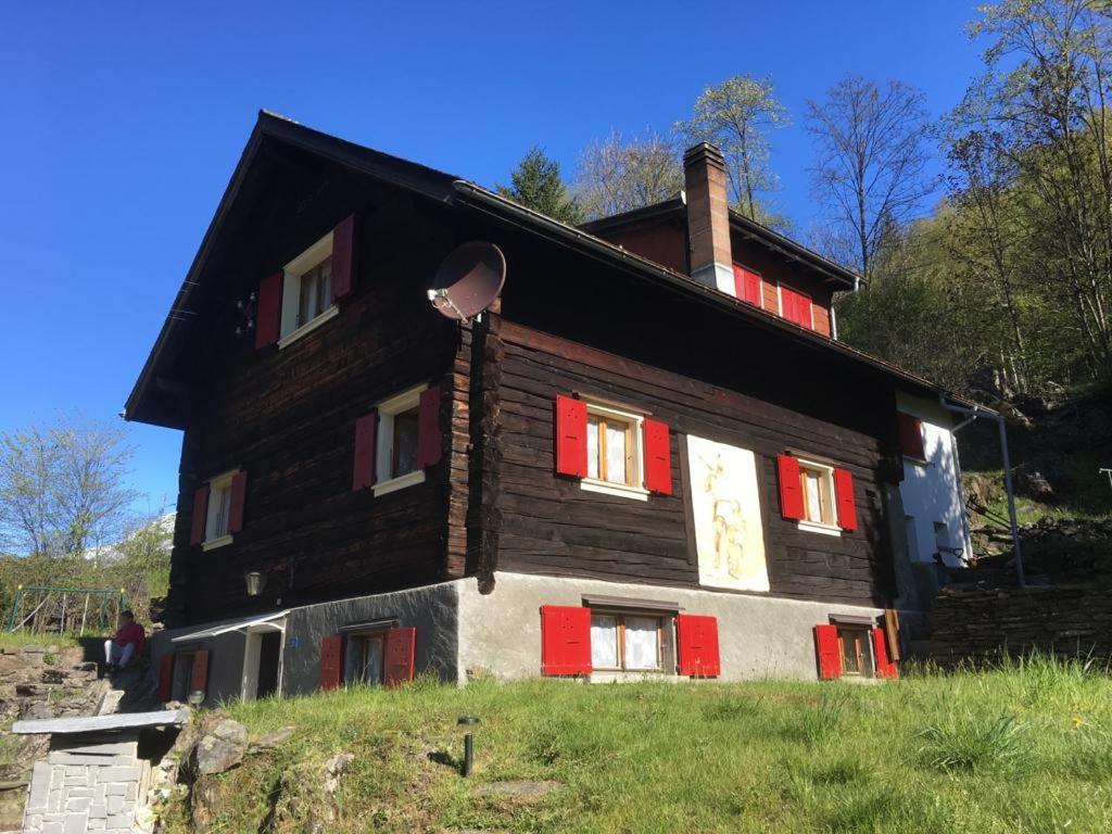 a large wooden house with red shutters at GuglielMotel in Quinto