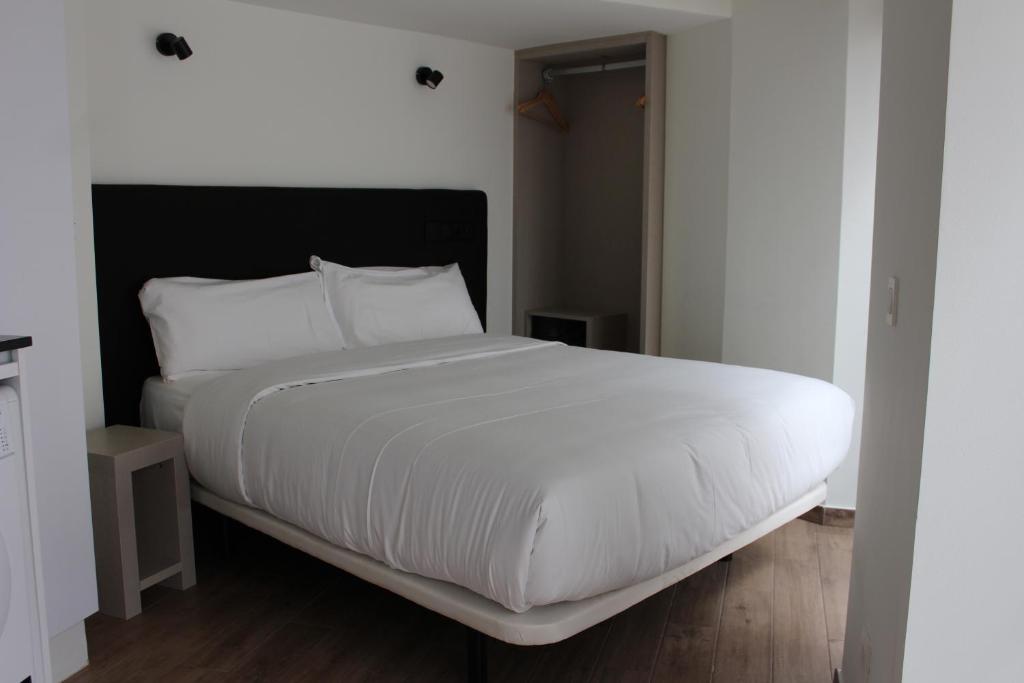 A bed or beds in a room at Apartamentos Centro Jardines