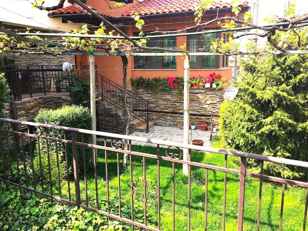 a fence in front of a house with a garden at Villa Rogachevi in Strelcha