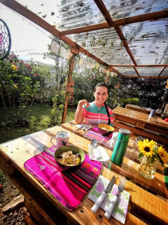 a woman sitting at a picnic table with a plate of food at Refugio Explora Verde in Choachí