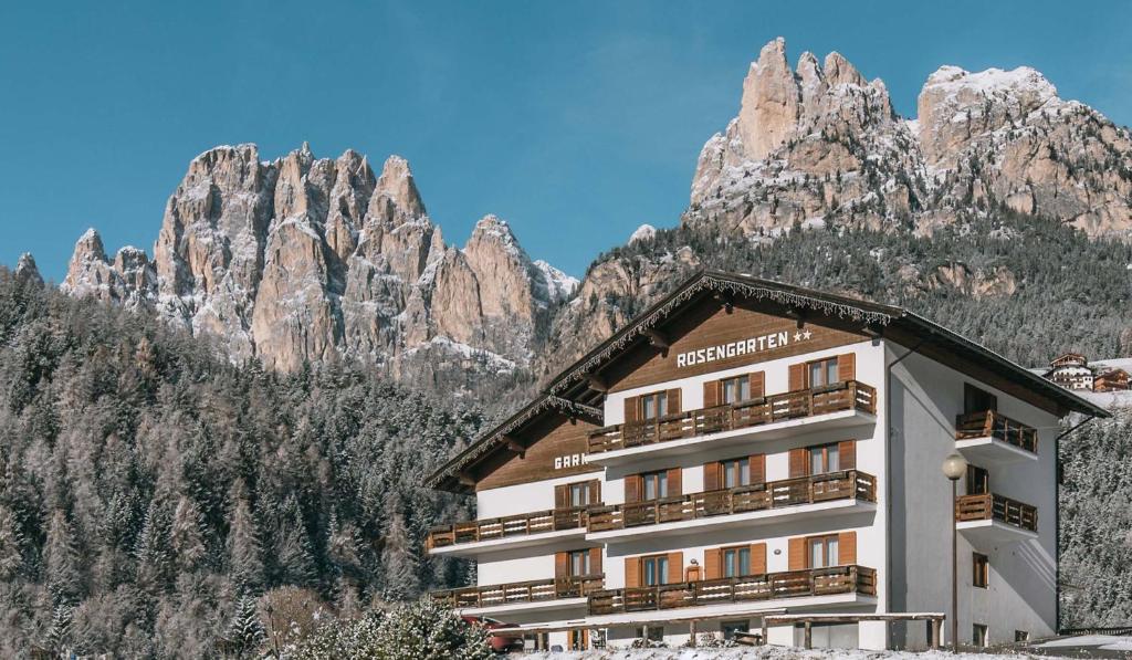 a hotel with mountains in the background at Hotel Garnì Rosengarten in Pera