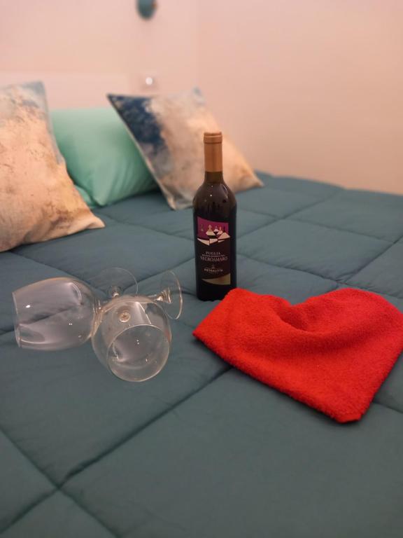 - Botella de vino y copas en la cama en AnSè 2.0, en Polignano a Mare