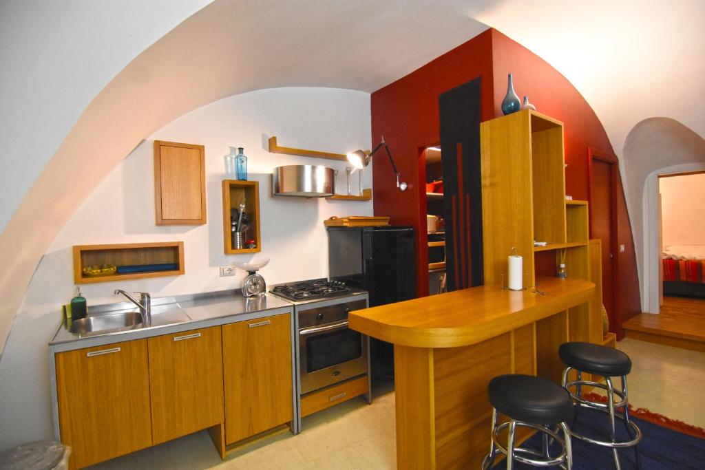 eine Küche mit Holzschränken und einer Theke mit Stühlen in der Unterkunft La Maison d'Adele in Neapel