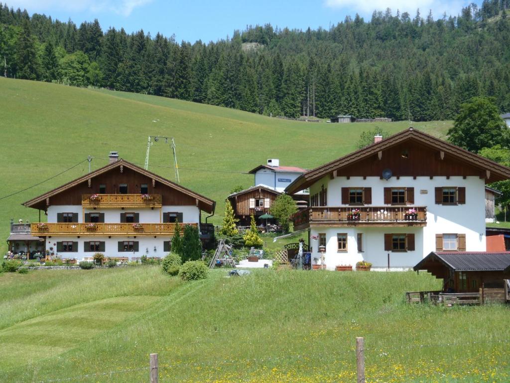 eine Gruppe von Gebäuden auf einem Feld mit Bäumen in der Unterkunft Fronwieshäusl Gschoßmann Johanna in Ramsau bei Berchtesgaden