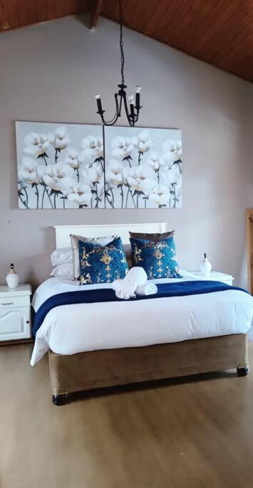 a bedroom with a bed with a painting on the wall at Mkababa's beautiful and spacious in Durban