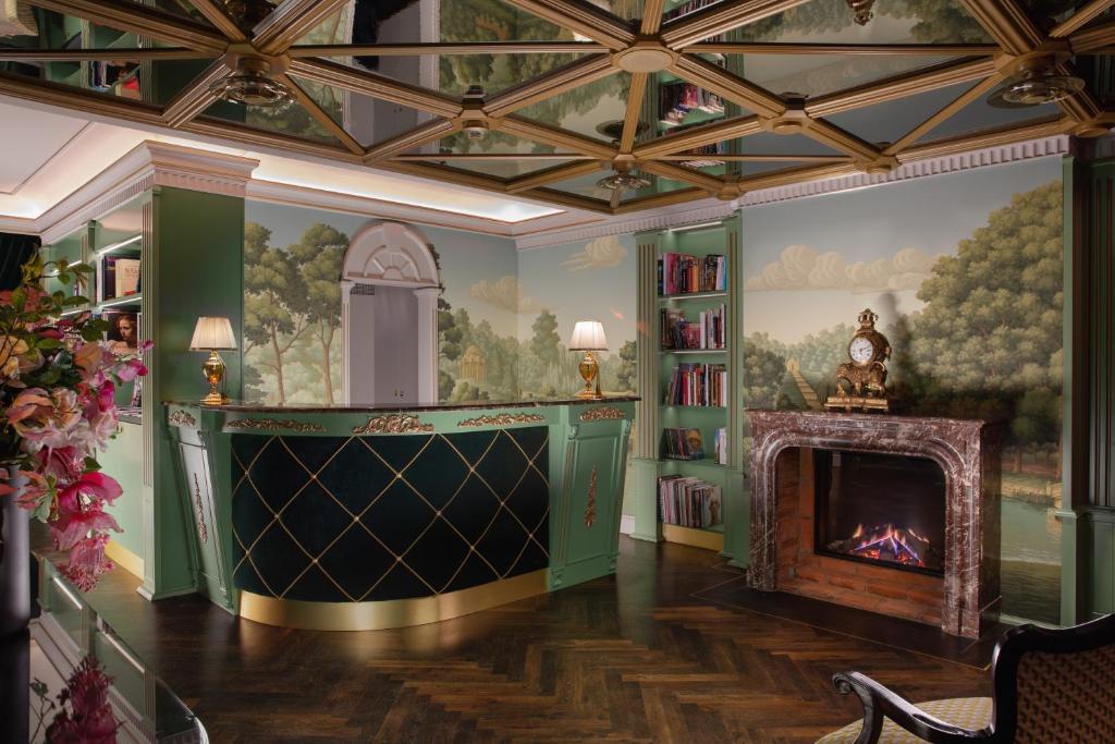 ein Wohnzimmer mit einem Kamin und einem Wandgemälde in der Unterkunft ARTIST Boutique Hotel in Wien