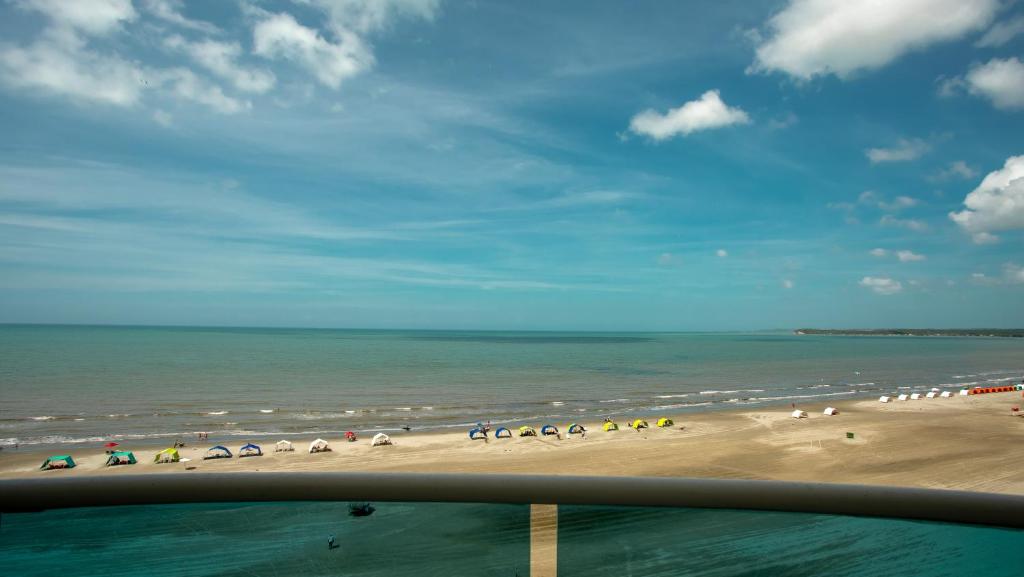 a view of a beach with umbrellas and the ocean at Apartamento con vista frontal al mar in Cartagena de Indias