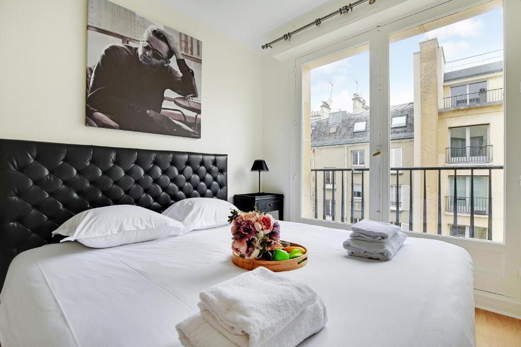 - une chambre avec un lit et une grande fenêtre dans l'établissement CMG Tour Eiffel/ New York, à Paris