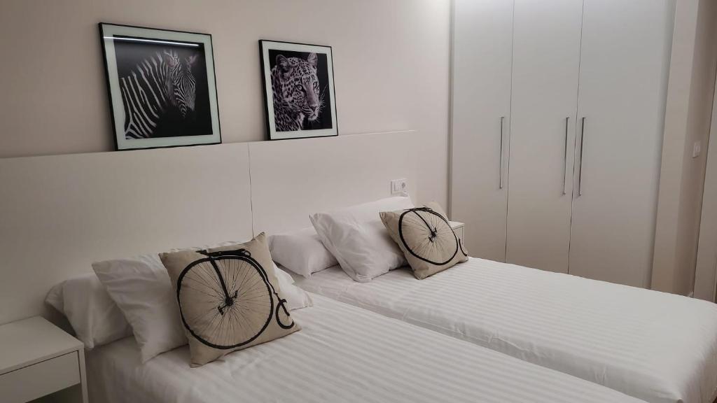 a white bed with two bike pillows on it at Cíes Luxury Suitel Lily Rodsen - Love your Stay in Vigo