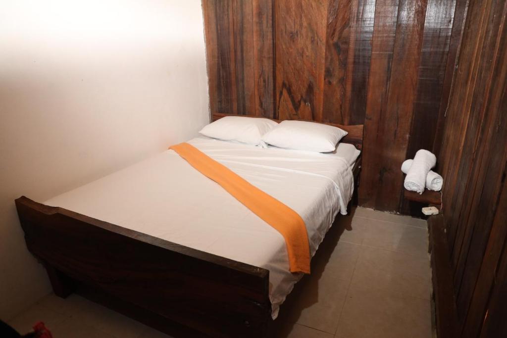 a bed with an orange ribbon on it in a room at La chonta in Capurganá