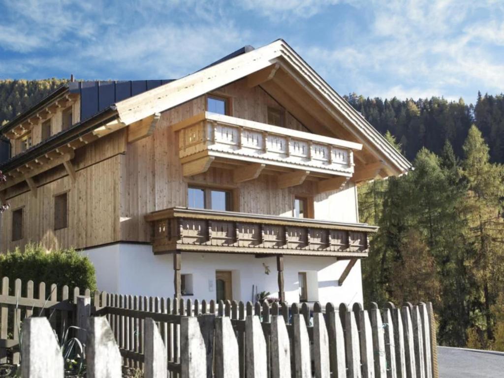 ein Holzhaus mit einem Zaun davor in der Unterkunft Kometer App Edelweiss in Fendels