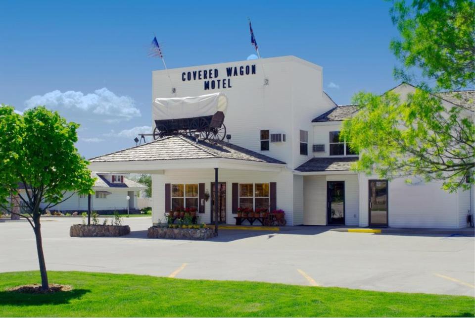 un edificio bianco con un cartello sopra di Covered Wagon Motel Lusk WY a Lusk