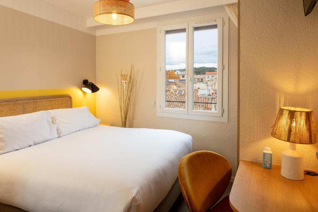 um quarto com uma cama branca e uma janela em Hôtel Escaletto em Aix-en-Provence