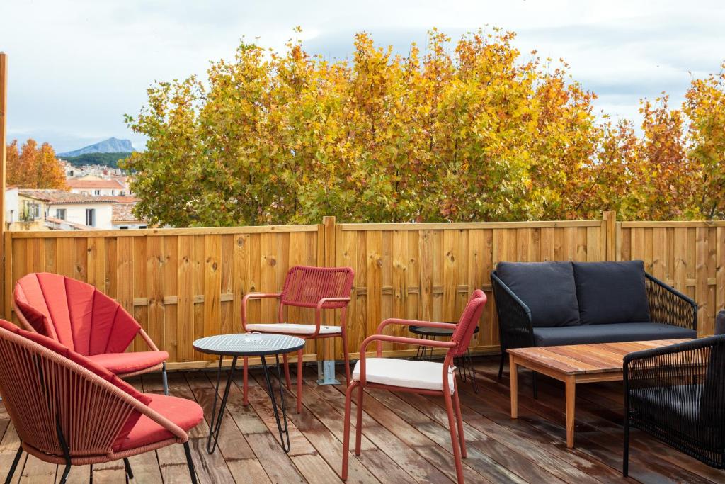 a group of chairs and tables on a deck at Hôtel Escaletto in Aix-en-Provence