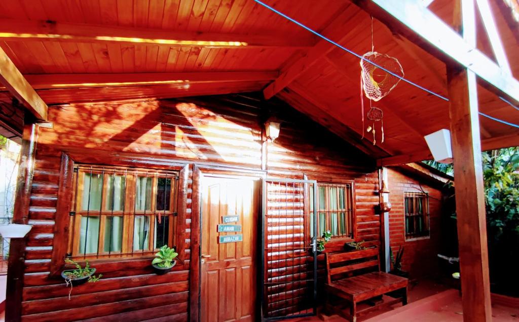 Cabaña de madera con banco en el porche en Cabaña El Ceibo en Puerto Iguazú