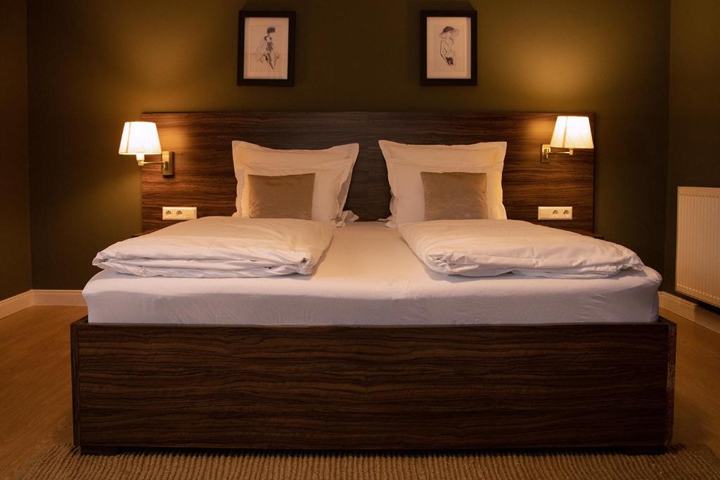 a bedroom with a large bed with two white pillows at Landhotel Wolfschlugen in Wolfschlugen