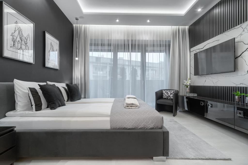 1 dormitorio con 1 cama grande y TV en Apartament Tokyo HANZA POOL, en Szczecin