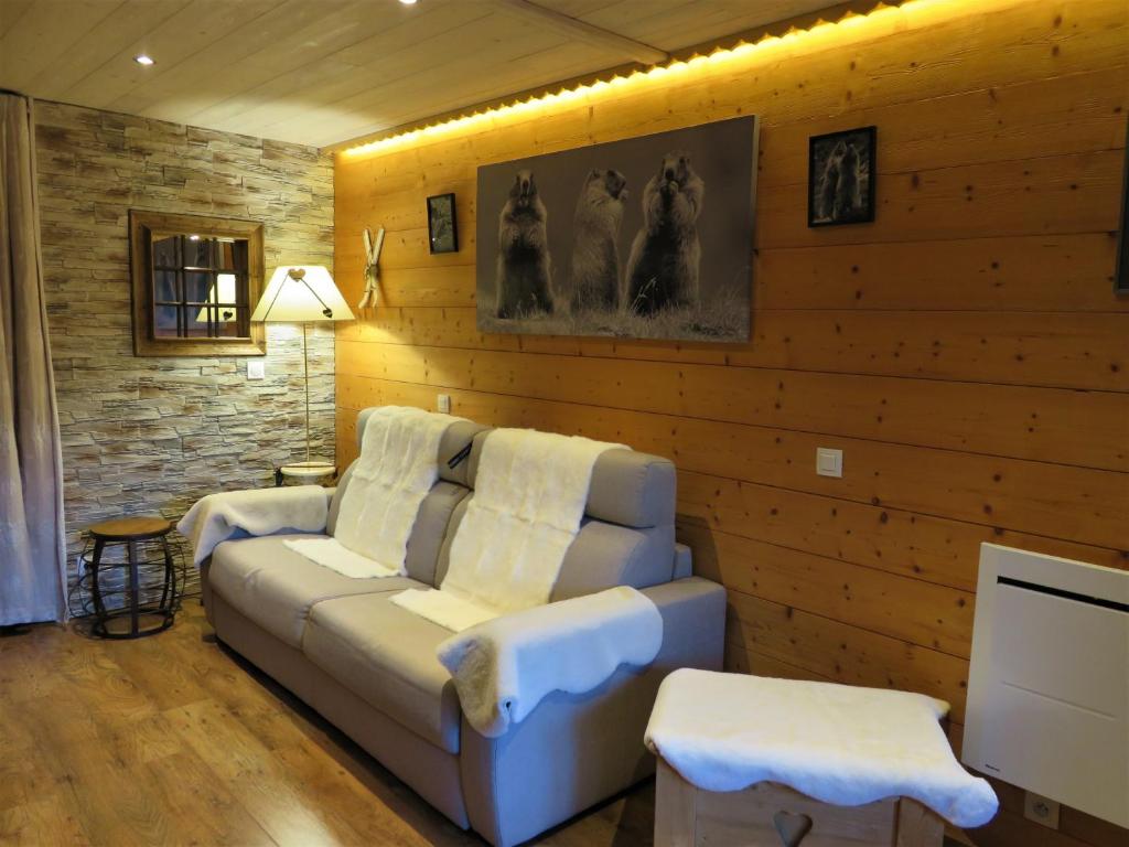 a living room with a couch and a television at Pensée Des Alpes 2 Etoiles Ski and Spa in Brides-les-Bains