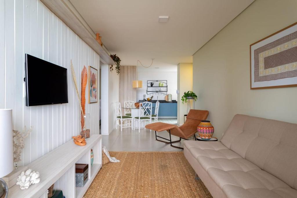 - un salon avec un canapé et une télévision dans l'établissement Apartamento com a cara de Maceió, à Maceió