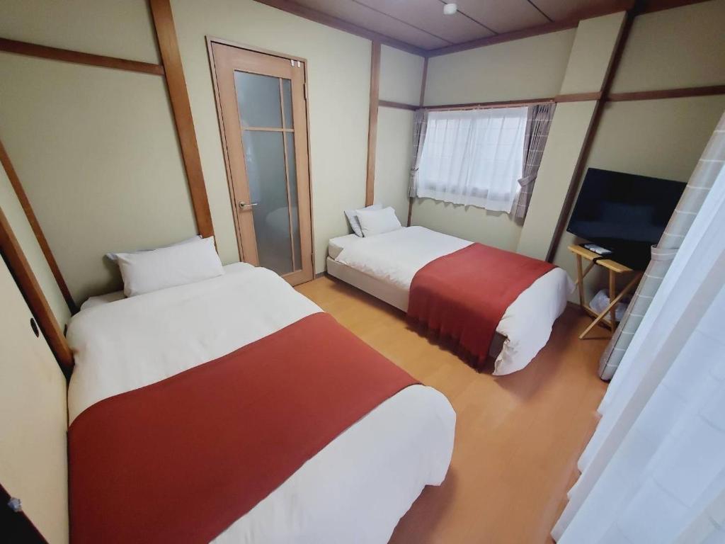 een hotelkamer met 2 bedden en een televisie bij Corp Temma - Vacation STAY 08144v in Takayama
