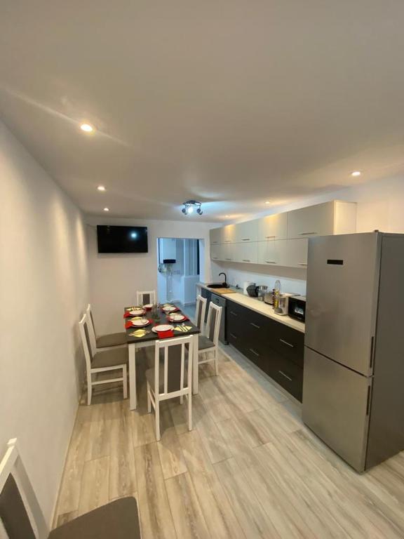 een keuken met een tafel en een witte koelkast bij Double D Apartments in Lupeni