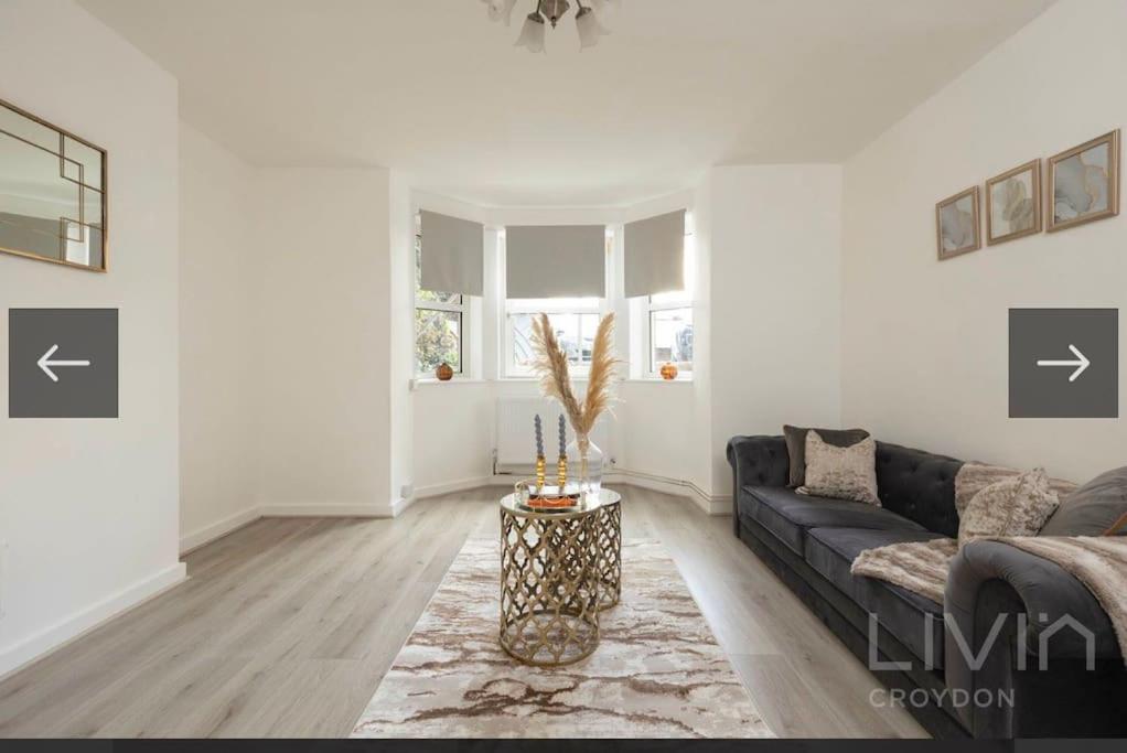 uma sala de estar com um sofá e uma mesa em Lovely 1 Bedroom Apartment em South Norwood