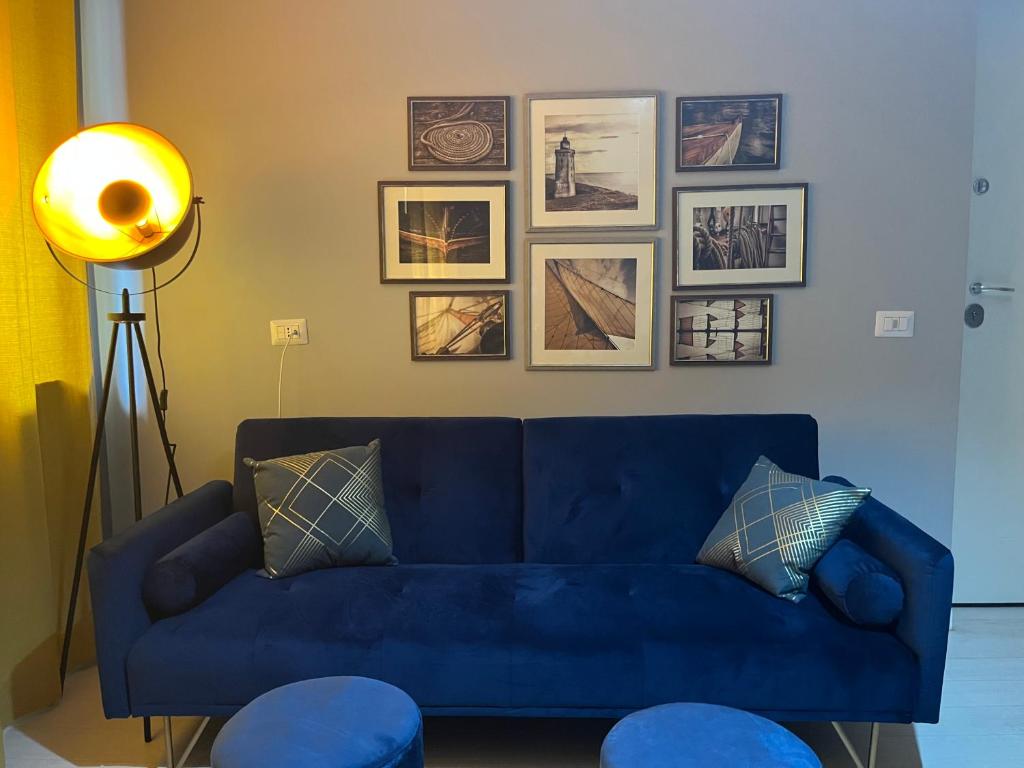 un sofá azul en una sala de estar con fotos en la pared en LUxRO Home en Crotone