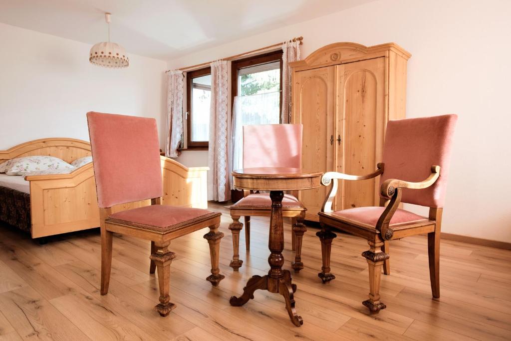 una camera con due sedie, un tavolo e un letto di Haus Fink a Innsbruck