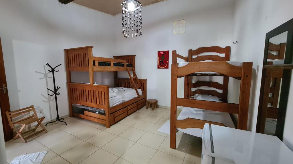 a room with two bunk beds and a table and chairs at Vila Shangri-la Algodoal- Suítes e Redário in Algodoal