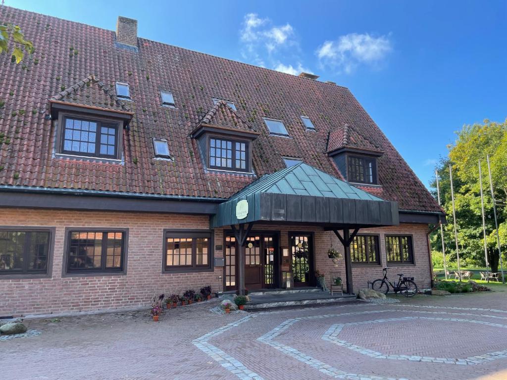 a large brick building with a red roof at Hotel Schloss Diepenbrock in Bocholt