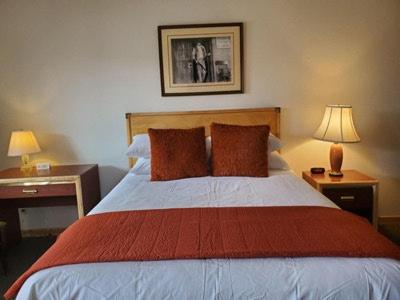 Old Montana Inn في Deer Lodge: غرفة نوم بسرير كبير مع وجود مصباحين على الطاولات