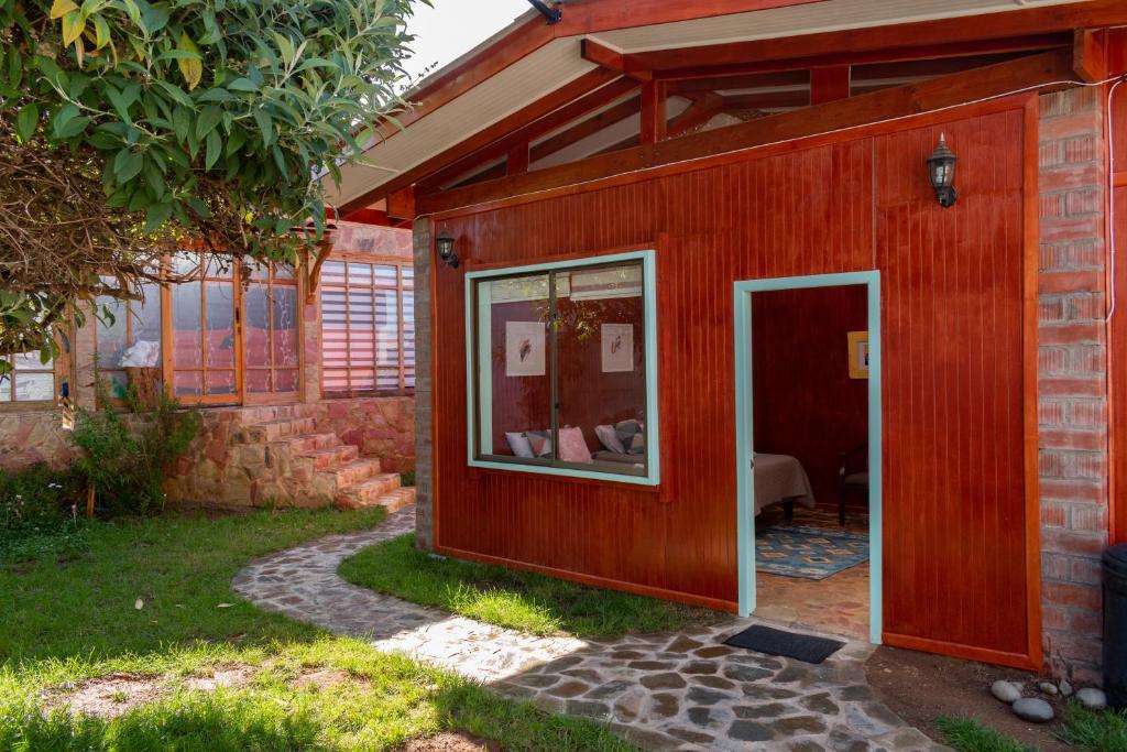 a small red house with a glass door at alojamiento Lof tüng in Los Vilos