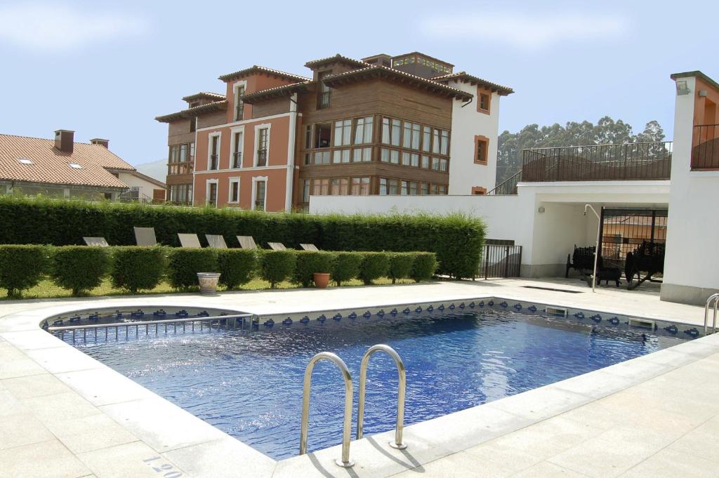 a swimming pool in front of a building at Hotel La Casona de Lupa in El Peñedo