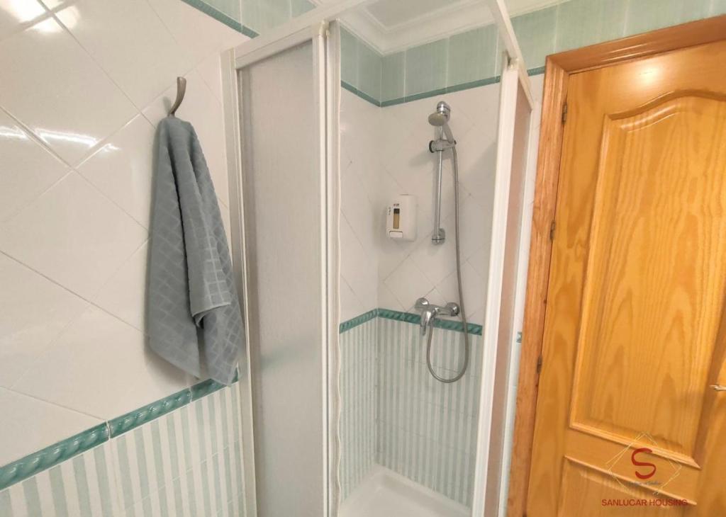 W łazience znajduje się prysznic ze szklanymi drzwiami. w obiekcie Doñana Playa a 50 metros de la playa by Sanlúcar Housing w mieście Sanlúcar de Barrameda