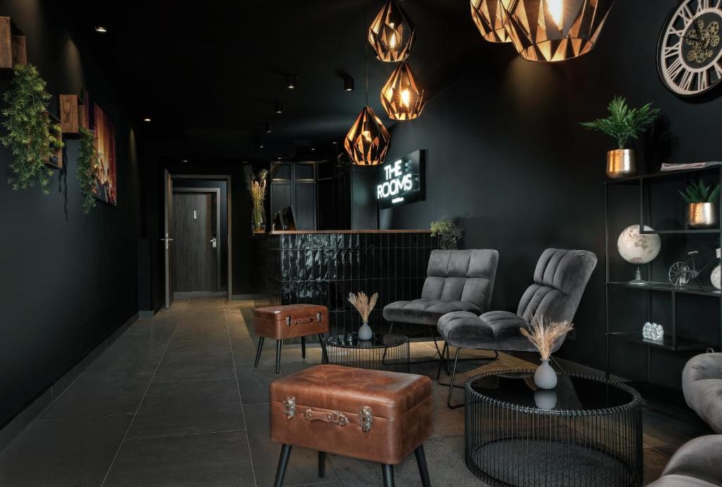 a lobby with chairs and tables and lights at THE ROOMS - Hotel & House in Frankfurt