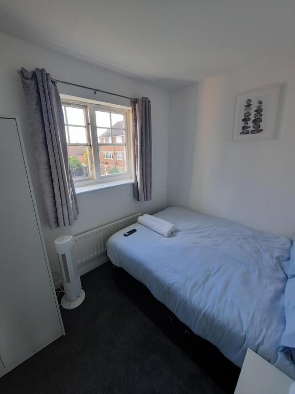 a small bedroom with a bed and a window at River View Two Bed Room Luxury Apartment in Thamesmead