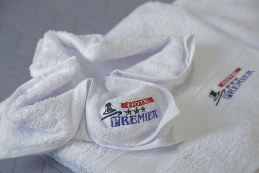 una pila de toallas blancas con un logotipo en ellas en Hostal Premier Arequipa, en Arequipa