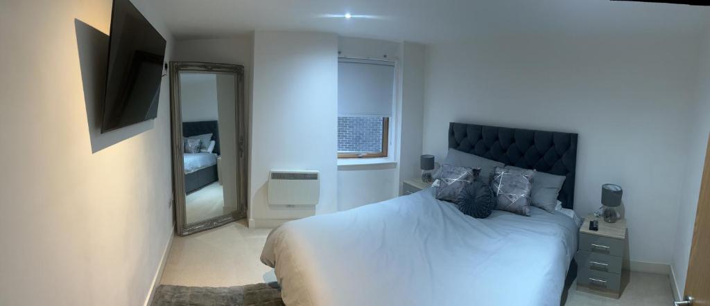 a bedroom with a large bed and a mirror at Sugarhill Leeds docks in Leeds