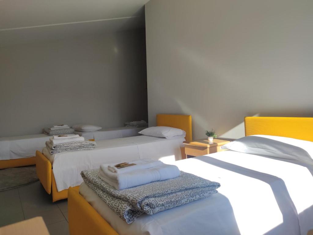 ein Schlafzimmer mit 2 Betten und Handtüchern darauf in der Unterkunft Lake and Mountain Suits in Verceia