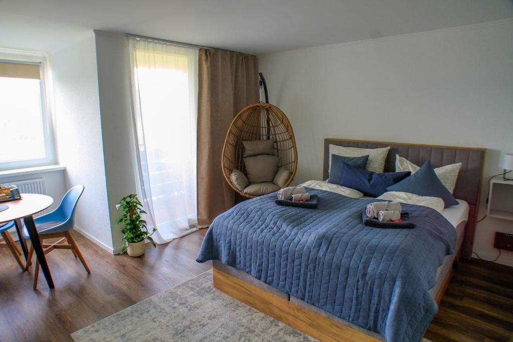 1 dormitorio con cama, mesa y espejo en Gemütliches Studio mit Ausblick, Pool und WiFi, en Baiersbronn